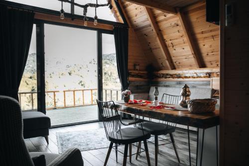 PazarÖmra bungalov的一间带桌椅和大窗户的用餐室