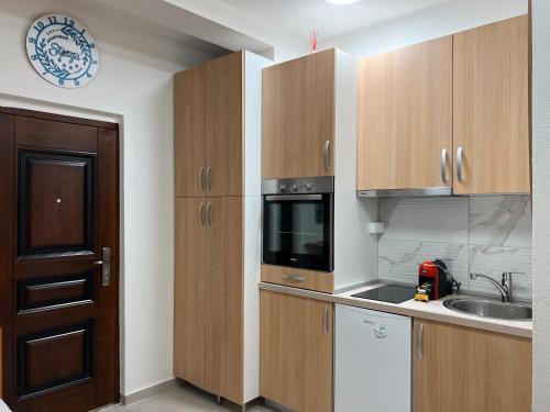 蒂瓦特Apartman Stasija的一间带木制橱柜和微波炉的厨房