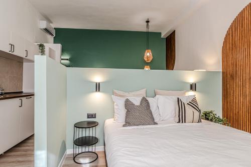 利沃诺Japandi, Appartamento Zona Porto Mediceo Livorno的卧室配有白色的床和绿色的墙壁