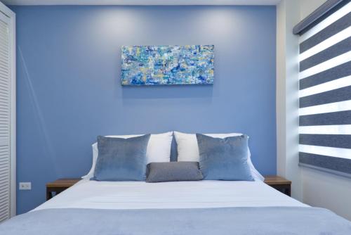 AroucaThe Cozy Condo的蓝色卧室,配有蓝色墙壁的床