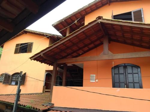 特林达德Pousada João e Maria的橙色的房子,设有窗户和屋顶