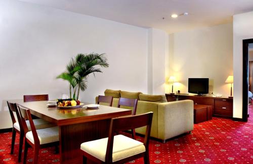 查亚普拉ASTON Jayapura Hotel and Convention Center的客厅配有桌椅和沙发