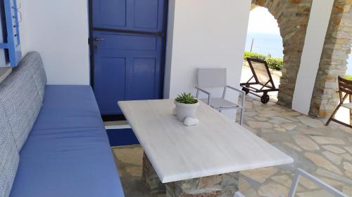 LigiaVeranda to Aegean的一个带桌子的门廊和一扇蓝色的门