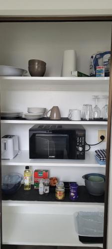 里夫顿Couples Retreat的厨房架配有微波炉、碗和餐具