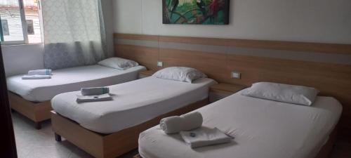 布卡拉曼加HOTEL GUADALUPE BGA的带三张床和窗户的客房