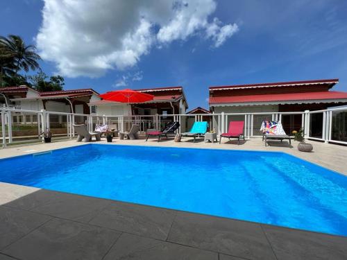 圣罗斯LE DOUX PARADISE的一座大蓝色游泳池,位于房子前