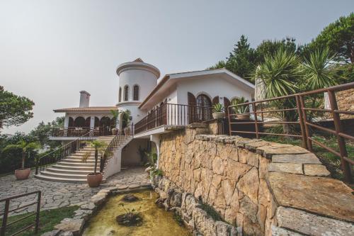 埃斯托利尔Villa Pietra Estoril Eco Guesthouse的一座带楼梯和石墙的房子