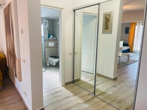 北马马亚-讷沃达里Rohan Studio One的带镜子的走廊和带卫生间的浴室