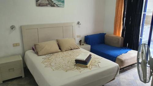 普拉亚布兰卡Marina Lucky的卧室配有白色的床和蓝色椅子