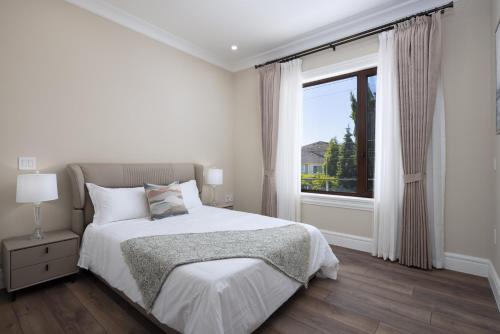 里士满Vancouver Vacation Home的白色的卧室设有床和窗户