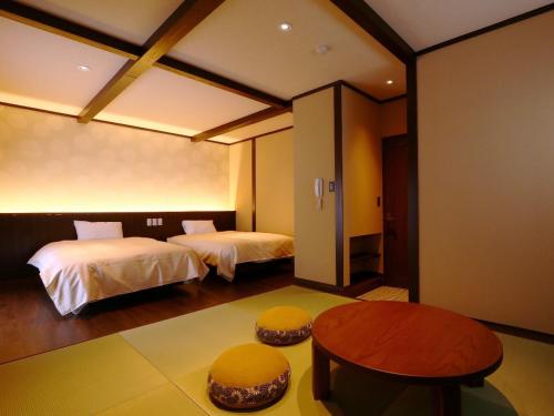 KihokuchoKii no Matsushima的酒店客房设有两张床和一张桌子。