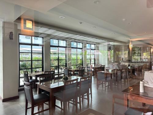 纳仲天红树林酒店 的用餐室设有桌椅和窗户。