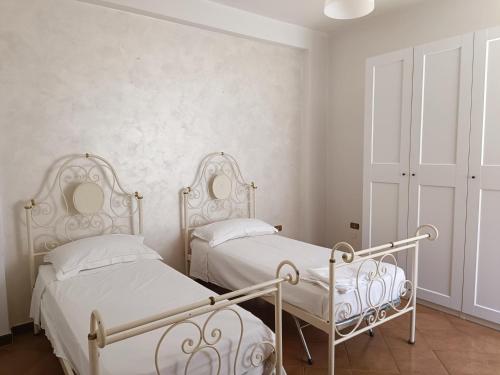 拉泰尔扎appartamento Alleria的卧室设有2张床和白色的墙壁。