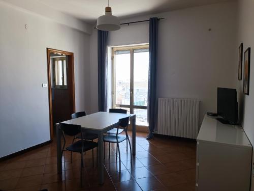 拉泰尔扎appartamento Alleria的一间带桌椅和窗户的用餐室