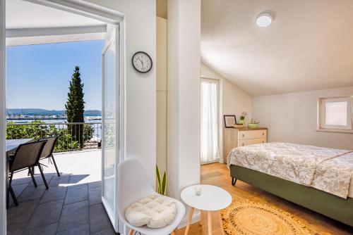 蒂瓦特Miro guesthouse的一间卧室配有一张床,阳台配有时钟
