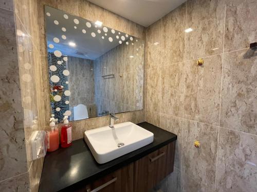 芭堤雅市中心森林大道Grand Avenue Condo的一间带水槽和镜子的浴室