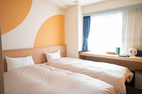 千岁Hotel Raffinato Chitose的卧室配有白色的床和窗户。