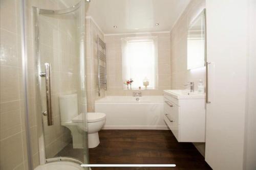 艾尔Beach lodge with Hot Tub的浴室配有卫生间、浴缸和水槽。