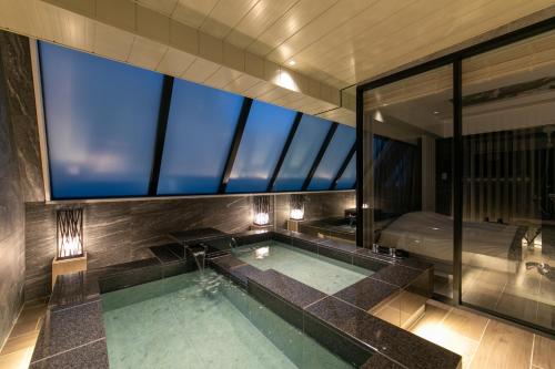 东京Hotel Karuta Akasaka的游泳池,浴室设有大窗户