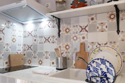 卡胡尔Nomad Sud Studios in Town Center的厨房的墙壁上铺有蓝色和白色的瓷砖。