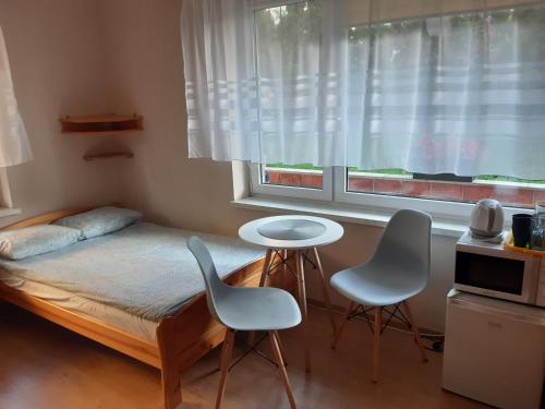 弗瓦迪斯瓦沃沃Joasia的一间卧室配有一张床、两把椅子和一个窗户