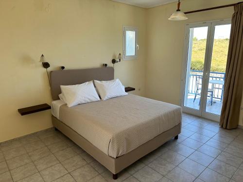 拉瑟解放村公寓式酒店的一间卧室设有一张床和一个阳台