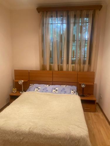 塞凡Коттедж на берегу оз. Севан的一间卧室配有床和带窗帘的窗户