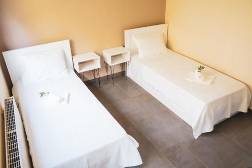 帕雷恩特西菲基昂Olea Residence Palio的客房内的两张床和白色床单