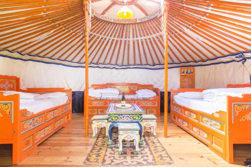 PaluelRando-Yourte的一间设有两张床的房间和一张帐篷内的桌子