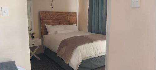 Berea HillsSeqonoka Villa Accommodation & Events Park的一间卧室配有一张带木制床头板的床