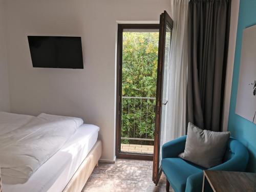 斯图加特Akteon Hotel的卧室配有床、椅子和窗户。