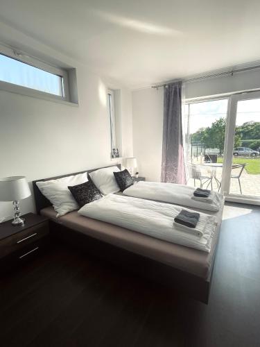 欧罗什哈佐Lux apartments的卧室内的一张大床,设有窗户