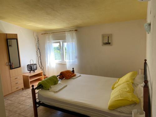 帕格Apartmani Fijan的一间卧室配有一张带黄色和绿色枕头的床