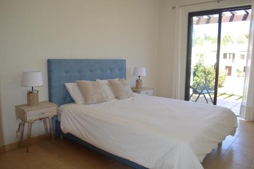 阿尔沃尔Luxury 1-Bedroom Apartment Alvor Duo Village的一间卧室配有一张大床和蓝色床头板