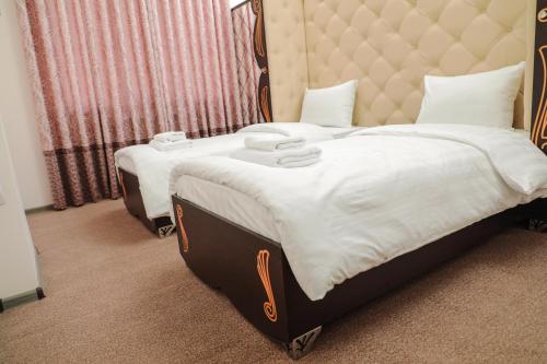 苦盏Khujand Star的一间卧室配有一张大床和床头板