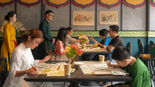 河内Smarana Hanoi Heritage - Hotel and Retreats的一群坐在餐厅桌子上的人