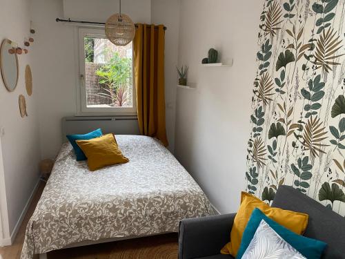 里尔Chez Jérôme的小卧室配有黄色和蓝色枕头的床