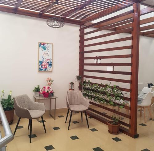 伊瓦拉HOTEL SHANGHAI CITY的一间设有椅子和桌子的房间和一堵植物墙