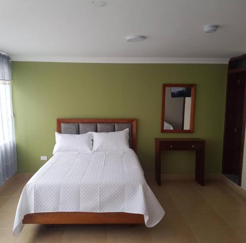 伊瓦拉HOTEL SHANGHAI CITY的卧室配有白色的床和绿色的墙壁
