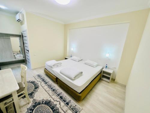 撒马尔罕Samarkand Travel Hotel的一间卧室配有一张床、一张桌子和一张书桌