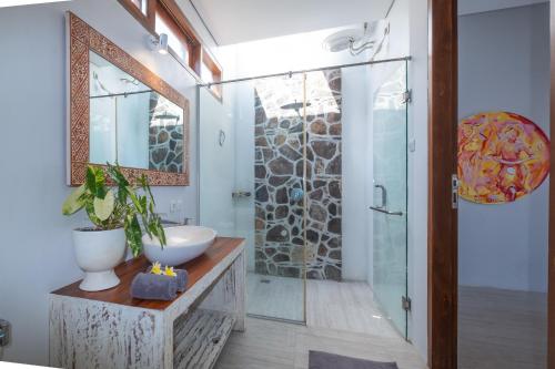芒希Kamana Beach House的一间带水槽和玻璃淋浴的浴室