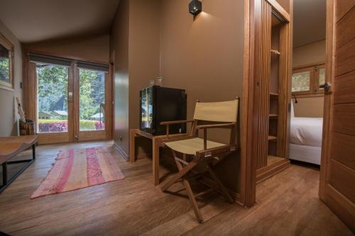 奥兰太坦波Las Qolqas EcoResort Ollantaytambo的客房设有书桌、电视和椅子。