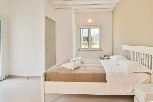 拉科纳B&B Villa Costanza的白色卧室配有一张带白色枕头的大床