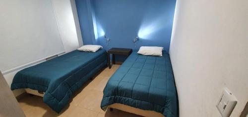 伊瓜苏港Departamentos Serena的蓝色的客房配有两张床和一张桌子