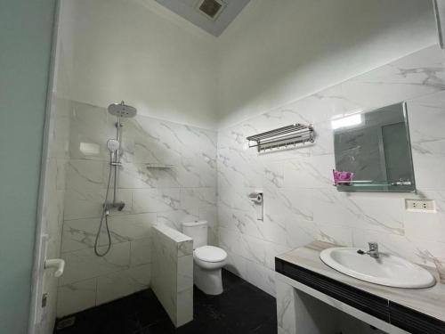 MuntokPondok Sahang Cottages的白色的浴室设有卫生间和水槽。