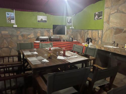 NarokSunset camp的餐厅设有木桌、椅子和柜台。
