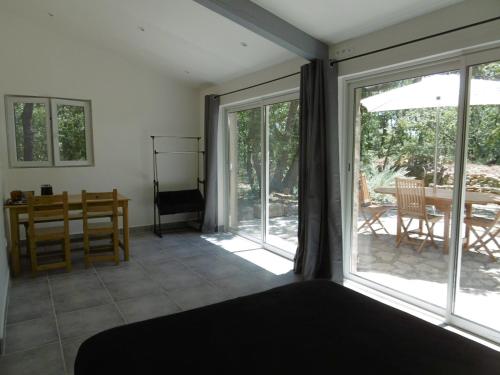 ViensPied à terre au coeur du Luberon, Provence的一间卧室设有一张床和一个滑动玻璃门