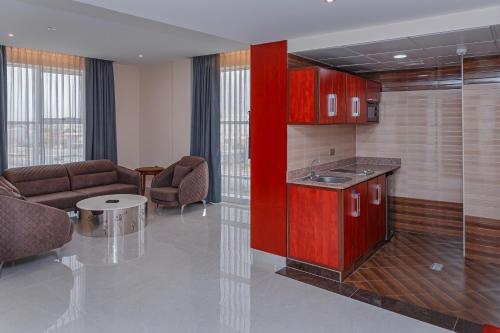 塞拉莱Salalah International Hotel的一间带红色橱柜的厨房和一间客厅
