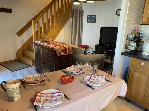 拉图多韦尔尼Maison au coeur du Sancy à la Tour d'Auvergne的桌子上放有盘子和酒杯