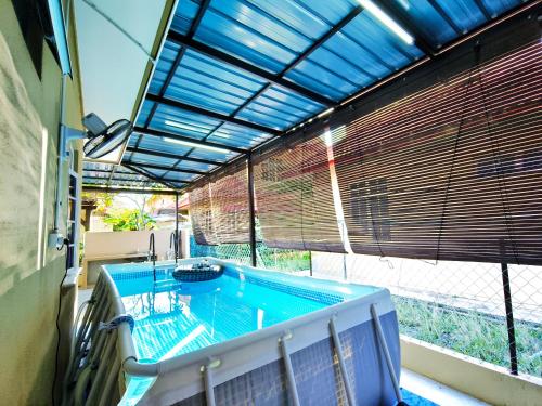 瓜拉丁加奴Ujana Damai - Cosy 5 bedrooms near UMT UNISZA的一座带大窗户的建筑中的游泳池